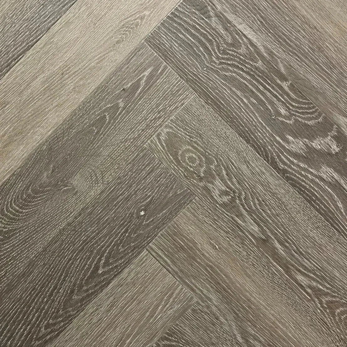 Spire Estyle Symphony Herringbone LVT flooring with wood-like pattern in a herringbone design, showcasing textured surface and warm tones.