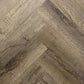 Spire Estyle Symphony Herringbone LVT flooring with a wood-like herringbone pattern in warm brown tones.